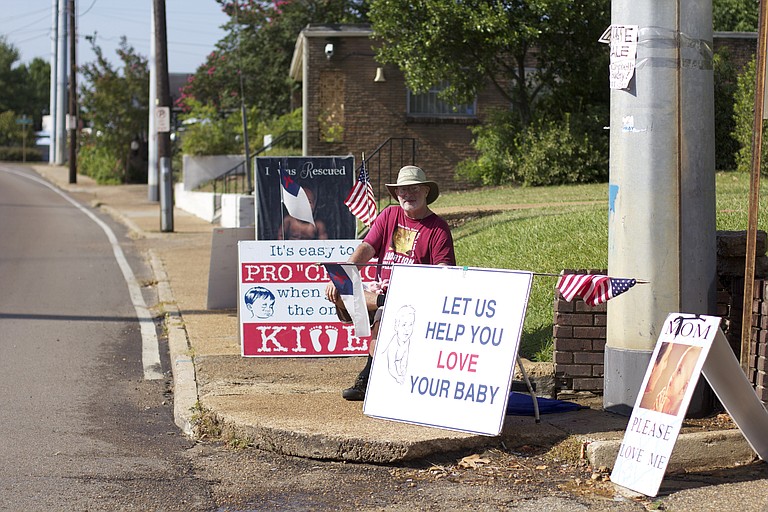 Protesters gathered outside the Jackson Women's Health Organization this morning after a federal judge moved last night to keep the clinic open at least 10 more days. Seated is Roy McMillan, husband of Pro-Life Mississippi President Beverly McMillan. The couple is also against birth control including the pill and the morning-after pill.