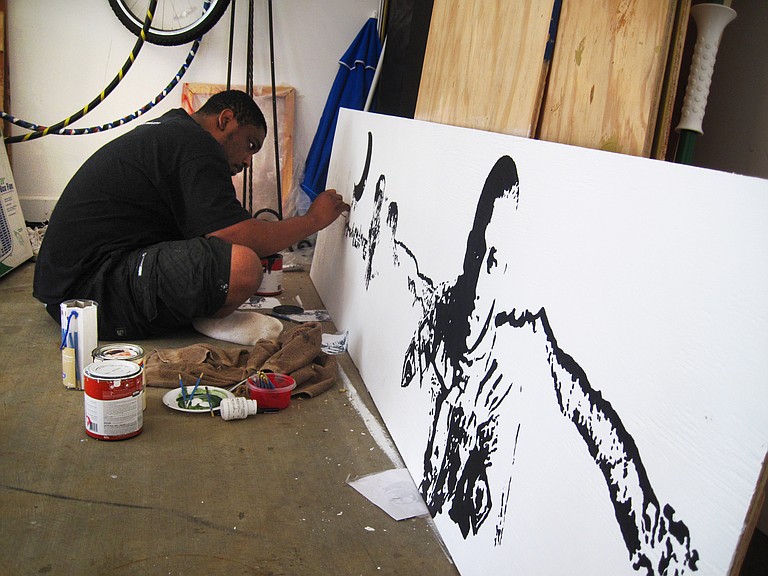 Charles Brice works on a panorama painting of his experiences in Afghanistan.