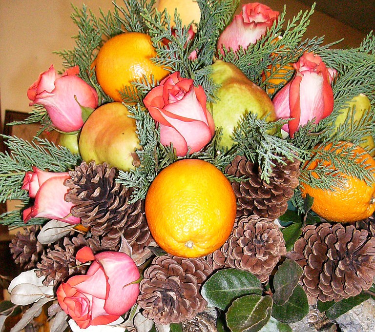 Incorporating pine cones and fruit can take more summery flowers, such as pastel roses, into fall. 