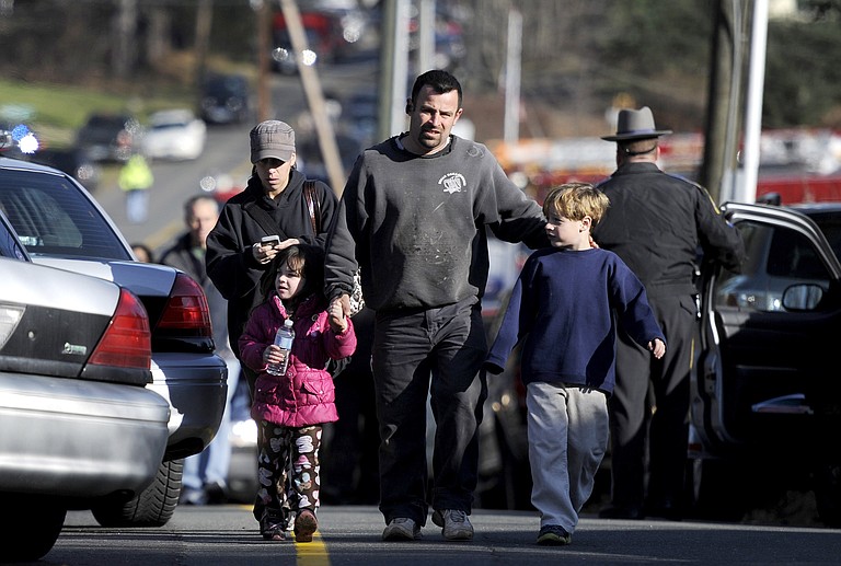 Parents leave a staging area after being reunited with their children following a shooting at the Sandy Hook Elementary School in Newtown, Conn., about 60 miles (96 kilometers) northeast of New York City, Friday, Dec. 14, 2012. An official with knowledge of Friday's shooting said 27 people were dead, including 18 children. It was the worst school shooting in the country's history.

