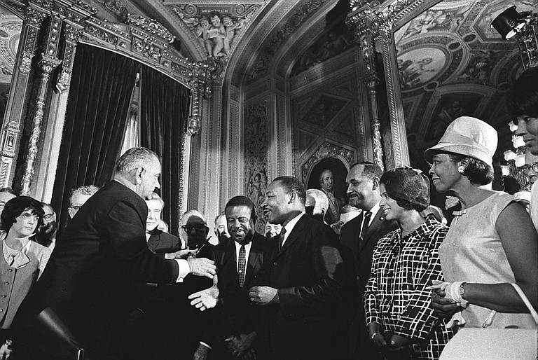 Martin Luther King Jr. meets with then-President Lyndon Johnson following the signing of the Voting Rights Act in 1965.