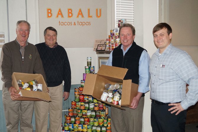 Stewpot Executive Director Frank Spencer (second from left) accepted more than 1,000 cans of food from (from left) Eat Here Brands Chairman Mike Stack, co-founder Bill Latham and Babalu General Manager Nate Delaware.