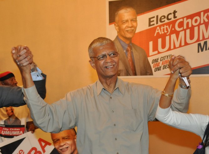 Chokwe Lumumba holds his son and daughter's hands as he walks in the Clarion Hotel's "Trinity II" room upon winning the Democratic Primary.