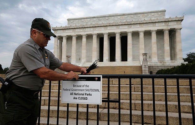 The National Park service's Richard Trott places a sign barring visitors to the Lincoln Memorial in Washington, October 1, 2013, because of the government shutdown.
