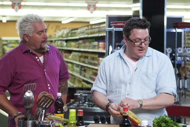 Local chef and restaurateur Tom Ramsey (right, with host Guy Fieri) will appear on the series premiere of the Food Network show “Guy’s Grocery Games.”