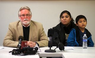 Law enforcement raided the home of Rosi Lopez (center) home in early December looking for a homicide suspect. Lopez, a U.S. citizen, said her family was a victim of racial profiling because the officer beat her and a relative and used ethnic slurs. She is pictured with Bill Chandler (left) and her son.