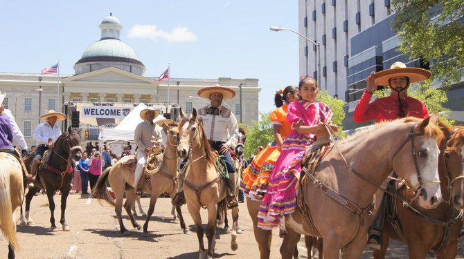 Charro Mexican Rodeo cowboys, Escaramuza cowgirls and American cowboys march in the Charro Mexican Rodeo parade during 2013’s Cinco de Mayo Festival.