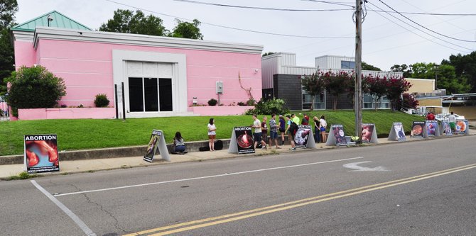 The police stood near Jackson Women's Health Organization, the last abortion clinic in Mississippi, on July 17 as Mike Peters picked up each of the large portable signs and took them to his building's basement./File Photo