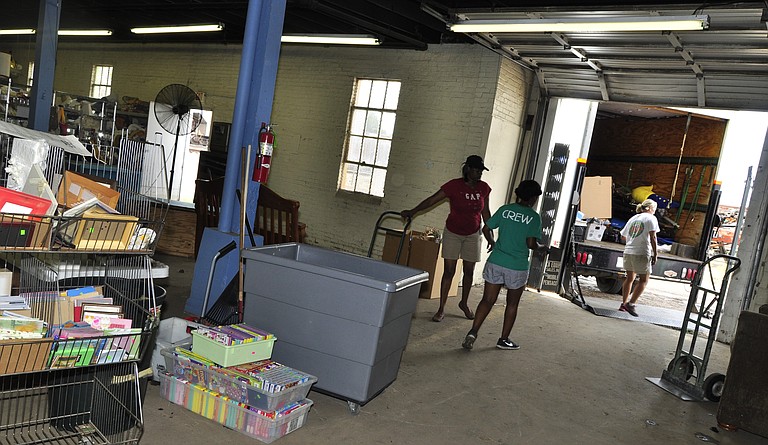 Volunteers arrived at NUTS Monday to start cleanup, which included pressure washing, bleaching and cleaning a layer of silt off the store's floor.