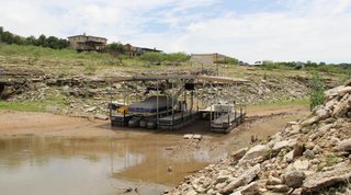 Texas Tech University professor Katharine Hayhoe works to connect events unfolding today—such as the 2012-2013 Texas drought—to climate change. Pictured is a boat stranded in Lake Travis, Texas, as waters recede in May, 2013.