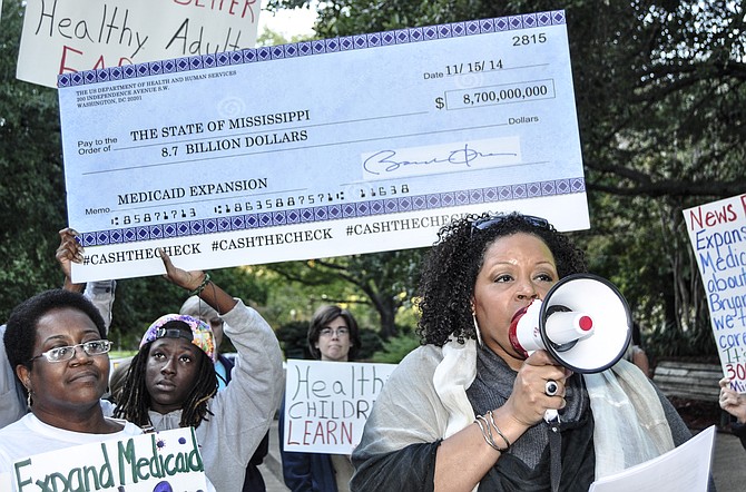 At a 2014 rally, demonstrators carried a large check for $8.7 billion that contained the signature of President Barack Obama to represent the amount the federal government would contribute if Mississippi loosened Medicaid eligibility requirements. File Photo.