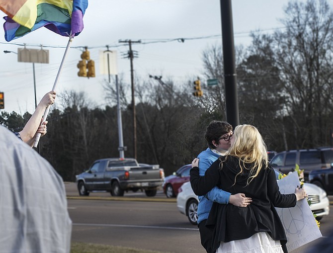Brandon High School Gay-Straight Alliance board member Presley McCord (right) and her boyfriend, Lucas Bonham (left), kiss by the highway in front of the Rankin County School District offices. Photo courtesy Anna Wolfe