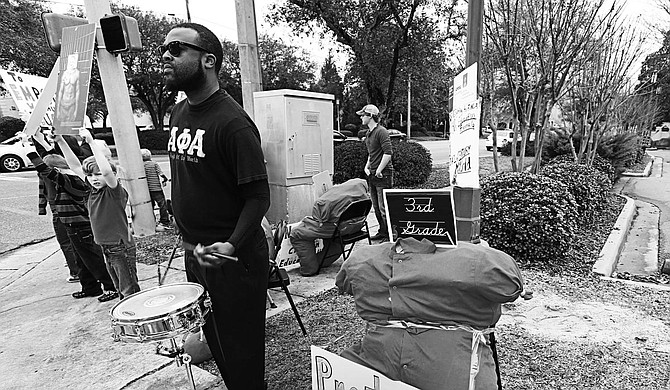 Bryan Eason, who often plays drums at the corner of High and North State streets, uses his instrument to draw people’s attention to education, poverty and race.