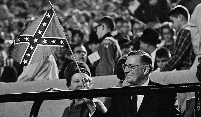 Gov. Ross Barnett was a leading defender of segregation in the 1960s and fought to keep James Meredith out of Ole Miss. Here, he waves a Confederate flag at the Sept, 29, 1962, Ole Miss vs. Kentucky football game to a frenzied crowd waving the flags against integration. Now, a large reservoir near Jackson is named after Barnett. Photo courtesy Associated Press/Jim Bourdier