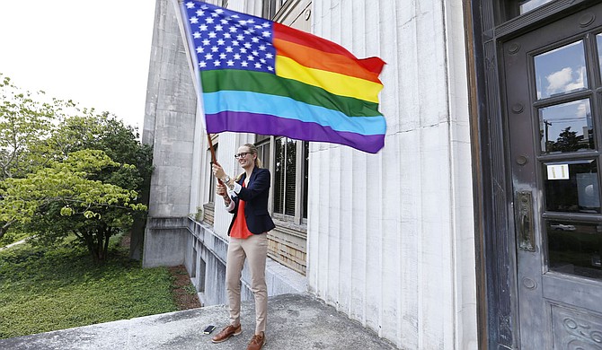 Lindsey Simerly waves a rainbow-themed American flag at the Hinds County Courthouse June 26 to celebrate a court ruling that legalized same-sex marriage nationally.