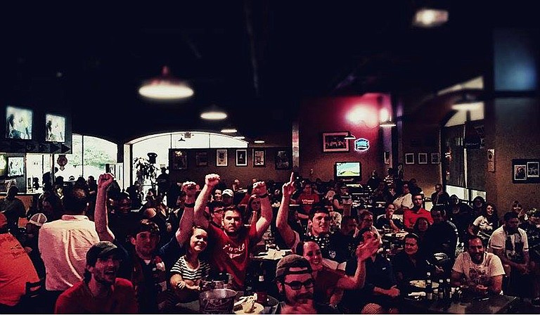 The Jackson chapter of American Outlaws, a nationwide soccer support association, cheer on the U.S. Women’s National Team as they watch the Women’s World Cup-winning game from Capitol Grill. Photo courtesy Lance GaM Mill