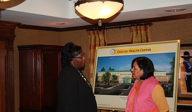 Agriculture Rural Development (RD) Mississippi State Director Trina George (left) and Mississippi Band of Choctaw Indians Chief Phyliss J. Anderson stand in front of a picture of the Choctaw Health Center building in Choctaw, MS on Tuesday, July 17, 2012. The tribe was awarded a $1 million grant for water and sewer upgrades to the Pearl River Community and the Health Center Development through the U.S. Department of Agriculture’s (USDA) Rural Development (RD) Water and Environmental Programs (WEP) Native American Grant programs. WEP provides loans, grants and loan guarantees for drinking water, sanitary sewer, solid waste and storm drainage facilities in rural areas and cities and towns of 10,000 or less. Photo courtesy Flickr/U.S. Department of Agriculture