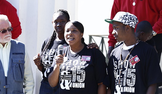Bill Chandler of the Mississippi Immigrants Rights Alliance (far left) stands on the steps of Jackson City Hall with local fast-food workers Cajania “CoCo” Brown, Kenyata McInnis and Tevin Tarrio (left to right).