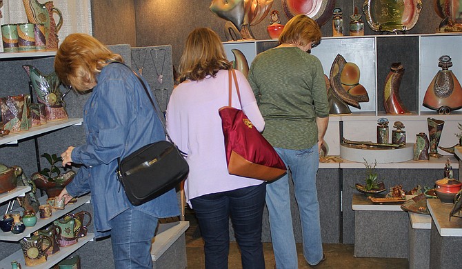 Chimneyville Craft Festival attendees browse the pottery in artist Helene Fielder’s booth at the event. Photo courtesy Craftsmen Guild of Mississippi