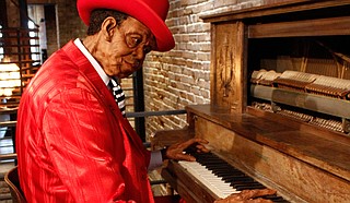 Blues musician Pinetop Perkins plays an old vertical piano.