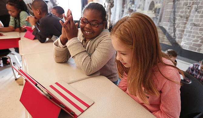 Quintaria Wright (left) and Avery Berg (right) work on a coding app called Lightbot during Eastside Elementary’s Hour of Code on Dec. 9.