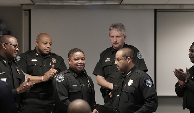 Officer Brandon Caston (center) was recently named Jackson Police Department’s Officer of the Month for March for collaring two suspected carjackers when he was off duty. To his right, Police Chief Lee Vance presented him with an award.