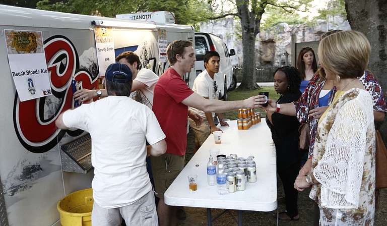 Beer vendors hand out samples of beer at last year’s Zoo Brew.