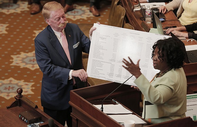 Rep. Jeff Smith, R-Columbus, (left) helps Rep. Omeria Scott, D-Laurel, show her poster boards displaying income-tax revenue numbers as she spoke on the Taxpayer Pay Raise Act on Monday in the House.
