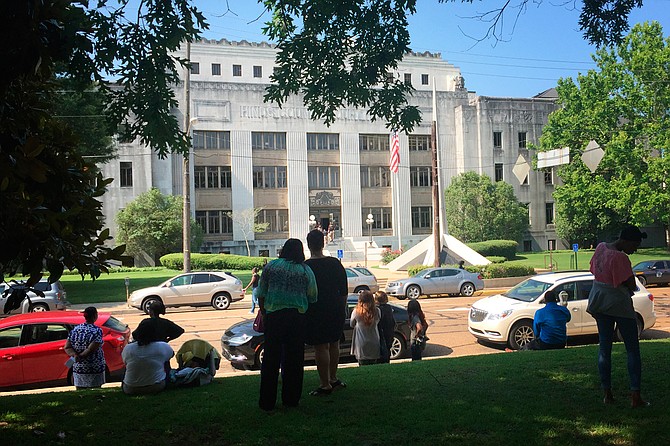 County employees and members of the public wait for the all-clear from Hinds County Sheriff's deputies as they search for explosives after a bomb threat Thursday morning.