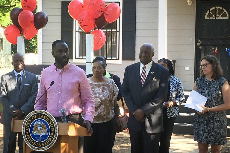 Mayor Tony Yarber and representatives from the U.S. Department of Housing and Urban Development gather in front of Bobbie Clay's newly refurbished home, a result of the Jackson Gateway project.
