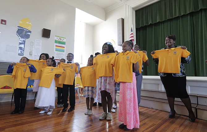 Watkins Elementary School students hold up their new spirit polo shirts.