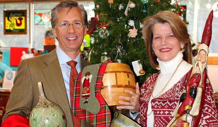 Mayo Flynt, the chairman of the board of trustees at the Mississippi Museum of Art, and Renee Flynt, a former president of the Craftsmen Guild of Mississippi, pose with items from the Chimneyville Crafts Festival. Photo courtesy Nancy Perkins