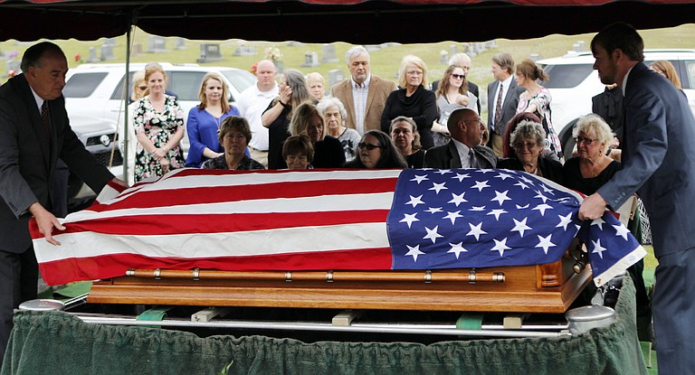 The flag-draped casket of Stanley Dearman, the former editor of The Neshoba Democrat newspaper in Philadelphia, Miss., is placed before his family, Tuesday, Feb. 28, 2017. Dearman edited the Democrat for 34 years. (Mike Robertson/The Neshoba Democrat, via AP)