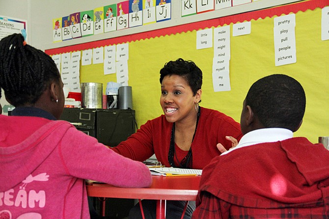 In this 2014 photo, literacy coach Kristen Wells works with students at Emmalee Isable Elementary in west Jackson. Literacy coaches are used statewide to help teachers teach literacy and boost reading scores. Photo courtesy Jackie Mader/The Hechinger Report
