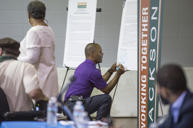 Ward 4 Councilman De’Keither Stamps signs the accountability board at the Working Together Jackson assembly Emmanuel Missionary Baptist Church in south Jackson. Stamps is unopposed for the June 6 general election.