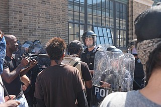 Hundreds of riot police mobilized downtown late Sunday, arresting more than 80 people and seizing weapons amid reports of property damage and vandalism. The arrests came after demonstrators ignored orders to disperse, police said. Photo courtesy Flickr/Paul Sableman