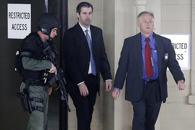 In this Monday, Dec. 5, 2016, file photo, former South Carolina officer Michael Slager (center) walks from the Charleston County Courthouse under the protection of the Charleston County Sheriff's Department after a mistrial was declared for his trial in Charleston, S.C. Photo courtesy AP/Mic Smith