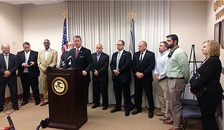 A federally organized drug task force arrested 11 people near Philadelphia, Miss., on May 30, U.S. Attorney Mike Hurst said at a press conference. Law enforcement personnel are standing behind him.