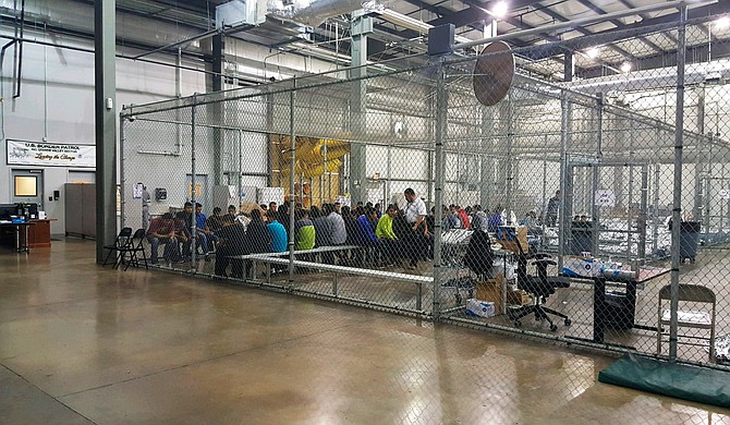 In this photo provided by U.S. Customs and Border Protection, people who've been taken into custody related to cases of illegal entry into the United States, sit in one of the cages at a facility in McAllen, Texas, Sunday, June 17, 2018.