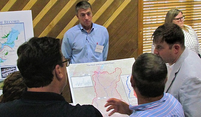 Community members listen as project engineer Brett Mendrop (center, striped shirt) describes the One Lake Flood and Drainage Control project.