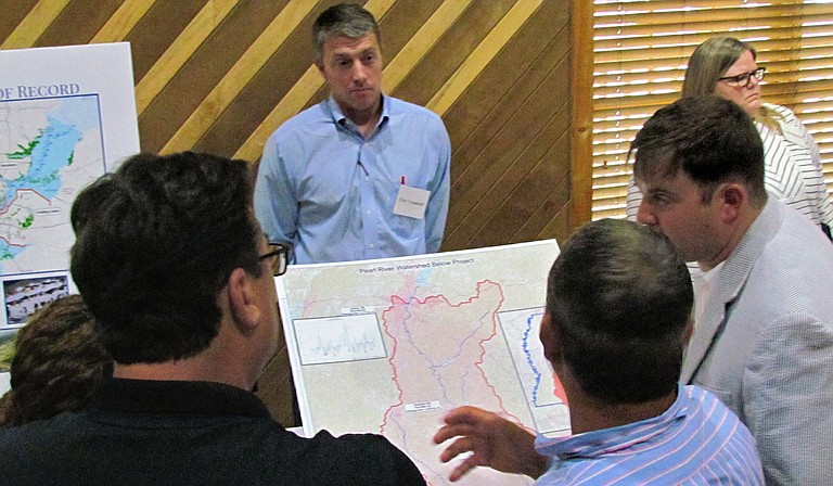 Community members listen as project engineer Brett Mendrop (center, striped shirt) describes the One Lake Flood and Drainage Control project.