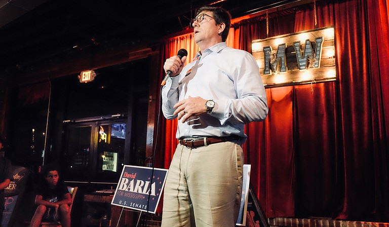 After winning the Democratic primary for U.S. Senate on June 26, 2018, Democrat David Baria speaks to a crowd of supporters in Gulfport, Miss., while his son, Max, 10, watches nearby.
