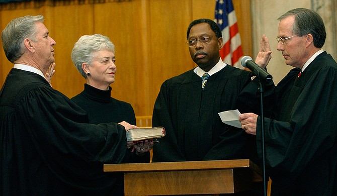 Charles Pickering, left, recites the oath of office, as he is sworn on to the 5th U.S. Circuit Court of Appeals on Friday, Jan. 16, 2004, at the federal courthouse in Jackson. Giving the oath is fellow Appeals Judge Rhesa Barksdale, right, while Pickering’s wife, Margaret Anne Pickering and Judge Henry T. Wingate watch. 