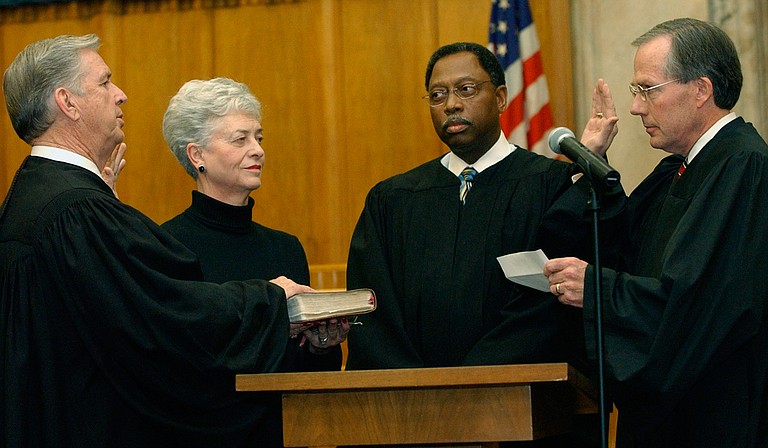 Charles Pickering, left, recites the oath of office, as he is sworn on to the 5th U.S. Circuit Court of Appeals on Friday, Jan. 16, 2004, at the federal courthouse in Jackson. Giving the oath is fellow Appeals Judge Rhesa Barksdale, right, while Pickering’s wife, Margaret Anne Pickering and Judge Henry T. Wingate watch. 
