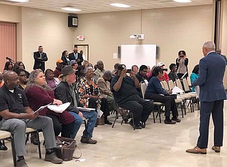 Frank Lawler, later identified as a “tracker” for the America Rising PAC, appeared at a Mike Espy (right) campaign event in Greenville, Miss., where Espy communications specialist Othor Cain (standing in the back, left) said the man falsely identified himself as Jackson Free Press reporter Ashton Pittman. He wears a red jacket and white Ole Miss cap. Courtesy Mike Espy campaign
