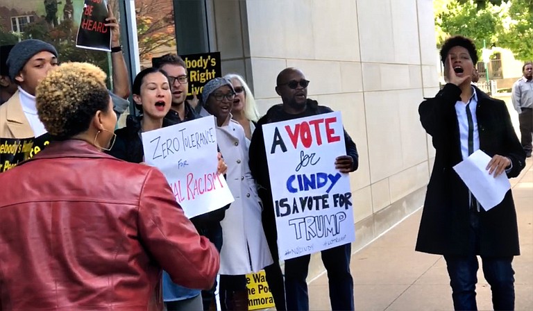 Approximately 30 protesters gathered on the sidewalk on Nov. 16, 2018, outside U.S. Sen. Cindy Hyde-Smith’s office, calling for her resignation. Co-organizer Genesis Be, a Gulf Coast native, is pictured to the right. Photo by Ko Bragg