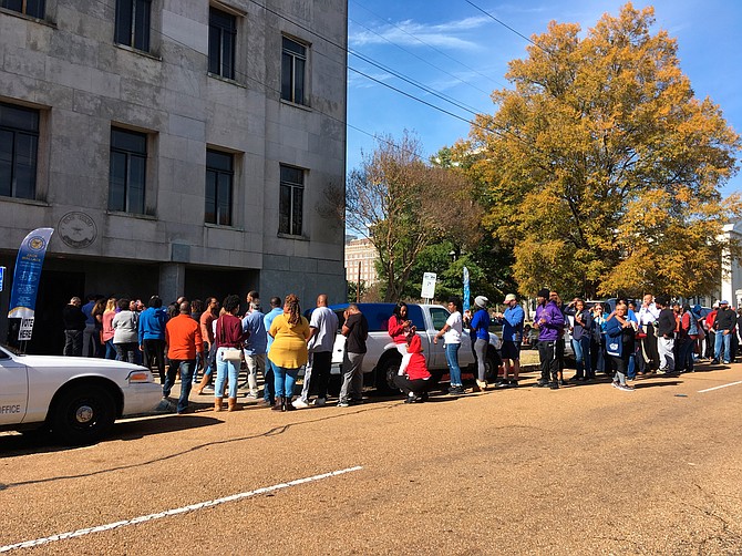 Several dozen people stood in line outside the Hinds County Courthouse in Jackson, Miss., on Saturday, Nov. 24, 2018, waiting to cast absentee ballots in a U.S. Senate election runoff between Republican Sen. Cindy Hyde-Smith and Democrat Mike Espy. Photo by AP/Emily Wagster Pettus