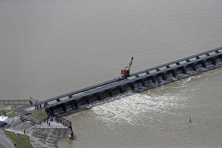 In this March 8, 2018 file photo workers open the gates of the Bonnet Carre spillway, a river diversion structure, which diverts water from the rising Mississippi River, left, to Lake Pontchartrain, in Norco, La. The Army Corps of Engineers’ New Orleans office is asking to open the historic flood control structure above New Orleans for the second time in one year. The National Weather Service says continued rains in the Midwest and Ohio Valley and floodwaters from the upper Mississippi River are heading down the Mississippi. File Photo by Gerald Herbert via AP