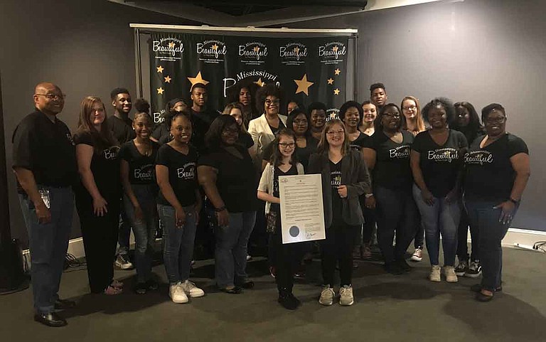 Jazz artist Pam Confer (center back) poses with choir members from Raymond Elementary School, Raymond High School and Terry High School, as Raymond Elementary School fifth-grader Trinity Spille (center) holds Gov. Phil Bryant's Mississippi Beautiful Day proclamation. Photo by Aliyah Veal