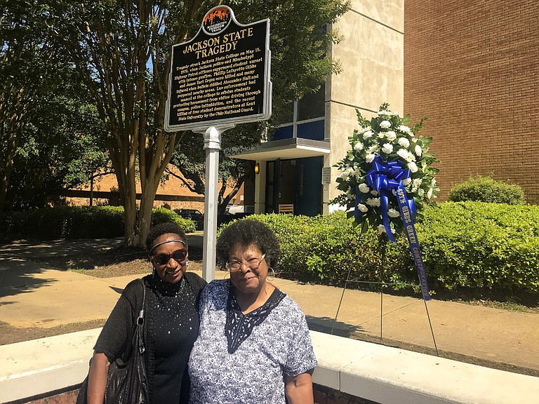 Gloria Green-McCray (right) and Mattie Hull (left) the sisters of James Earl Green, stand beside a marker and wreath outside Alexander Hall on the Jackson State University campus on May 15, 2019 - 49 years after city and state police opened fire on a group of youth, killing their brother and one other. Photo by Aliyah Veal
